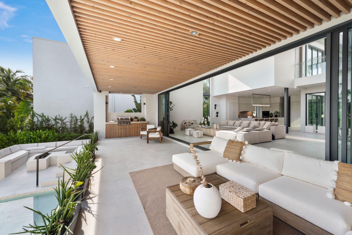 Covered outdoor living room opening to the pool