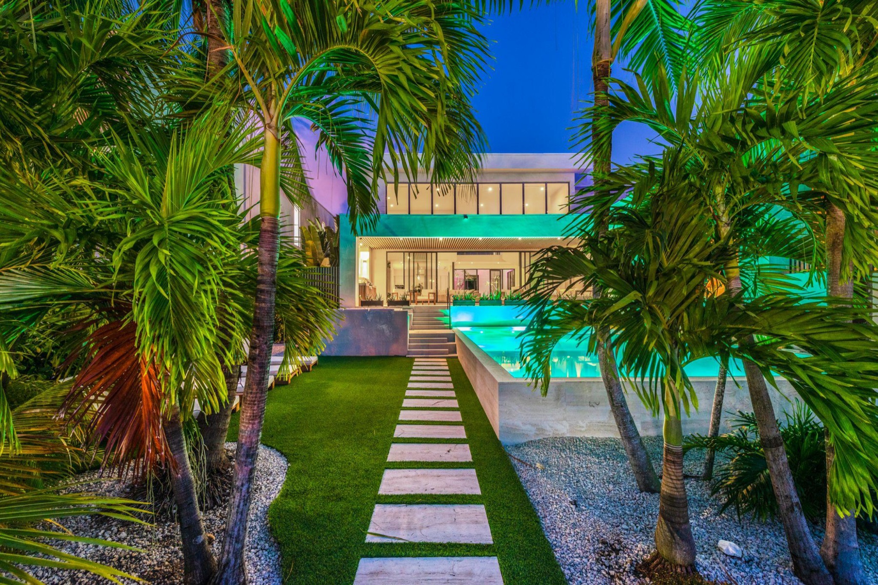 Miami residence at twilight with lit pool
